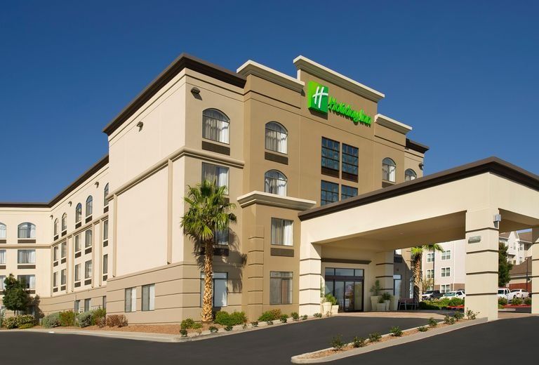 A large hotel with a palm tree in front of it