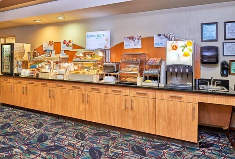 A restaurant with a long counter filled with food and drinks.