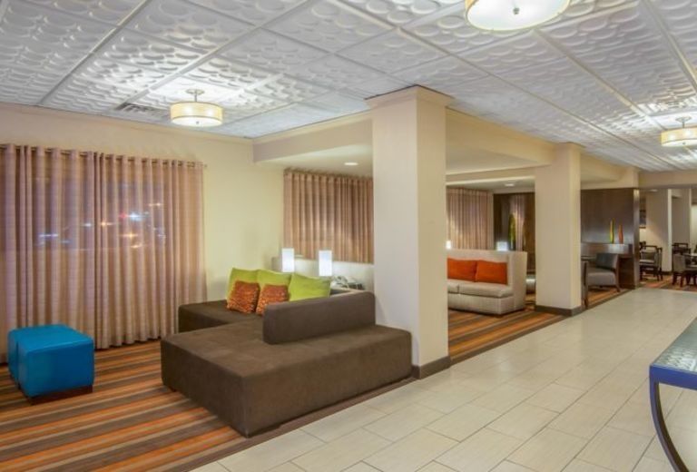 A hotel lobby with a couch and ottomans in it.