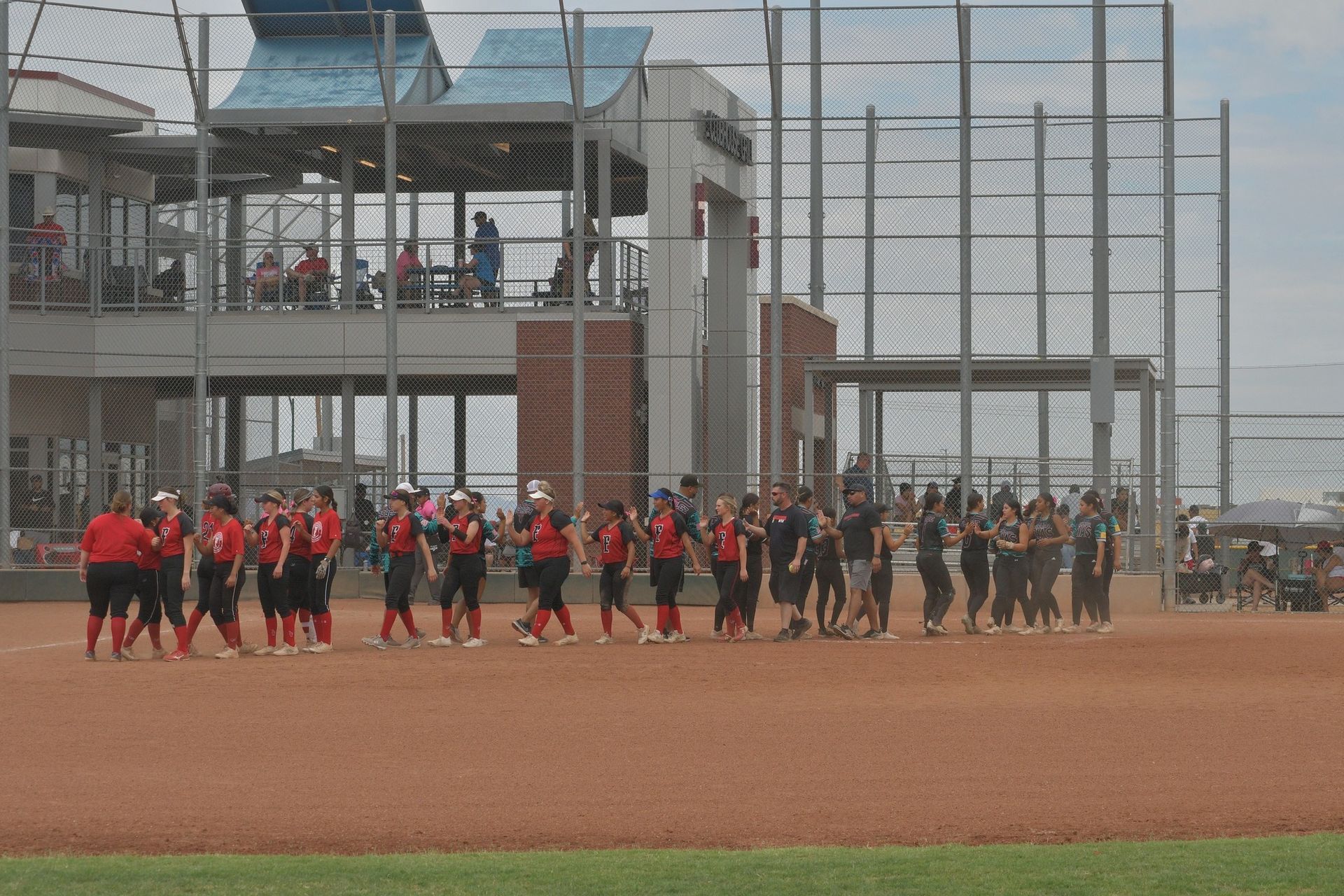 A group of people are walking on a baseball field.