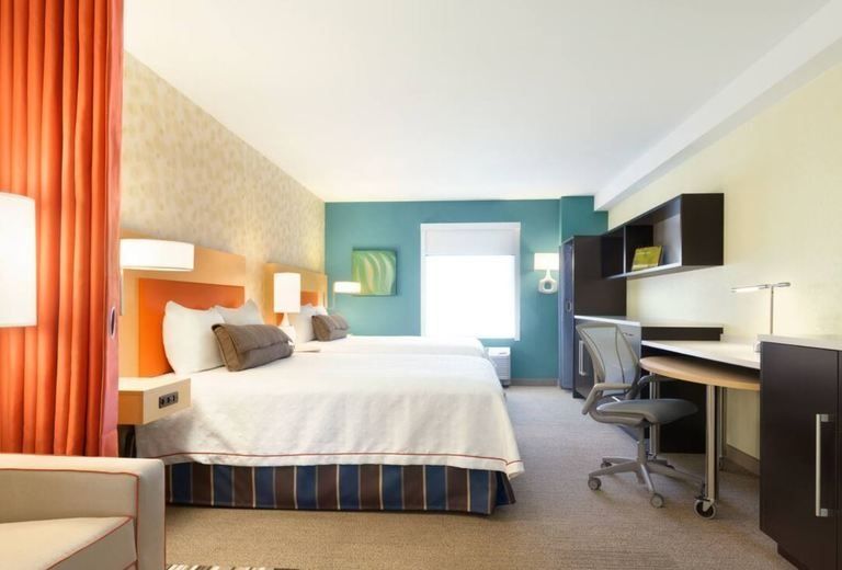 A hotel room with two beds and a desk
