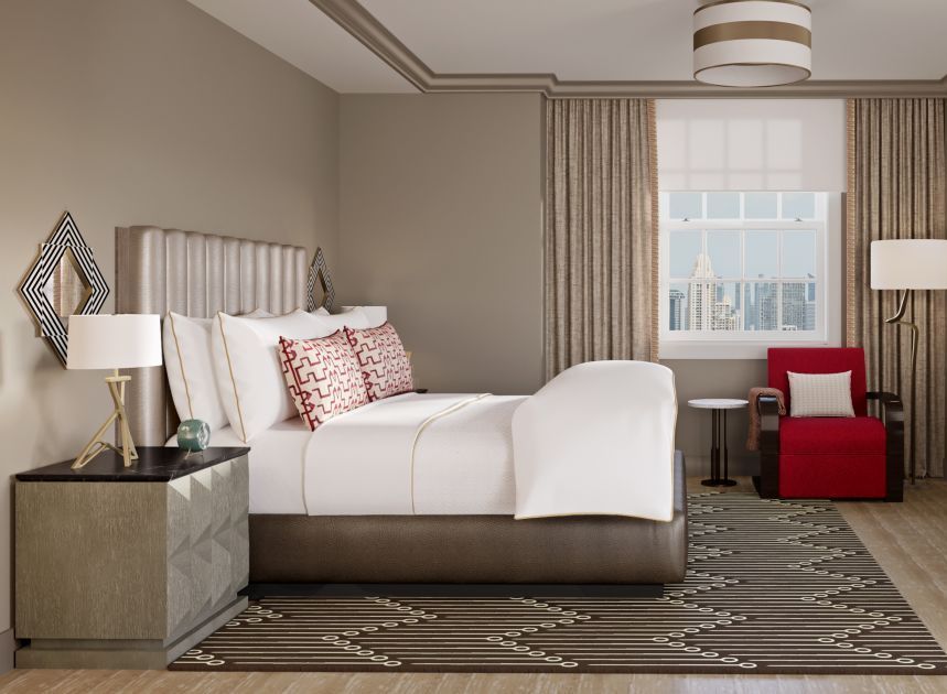 A bedroom with a large bed and a red chair
