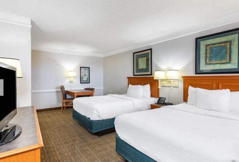 A hotel room with two beds and a flat screen tv
