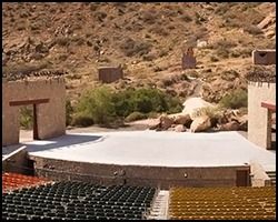 A large amphitheater with rows of seats in the desert.