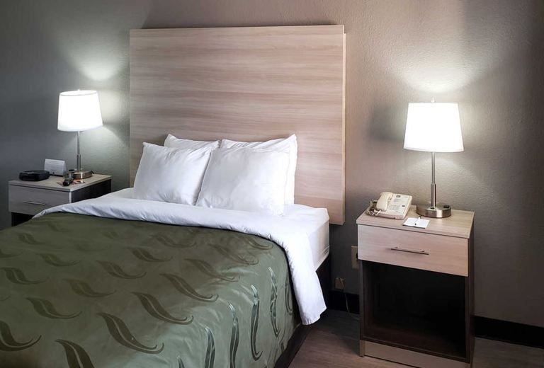 A hotel room with a bed and two nightstands