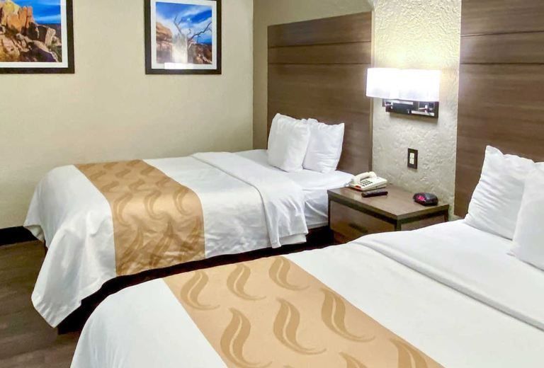 A hotel room with two beds and a nightstand