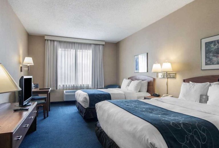 A hotel room with two beds and a television