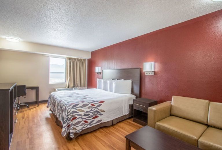 A hotel room with a king size bed and a couch.
