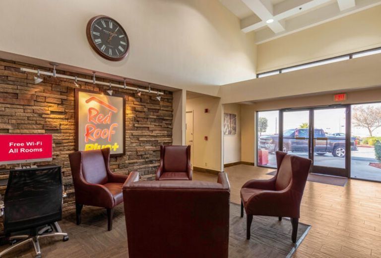 A hotel lobby with chairs and a clock on the wall.