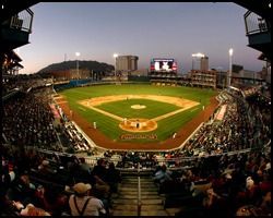 A baseball stadium filled with people watching a game.