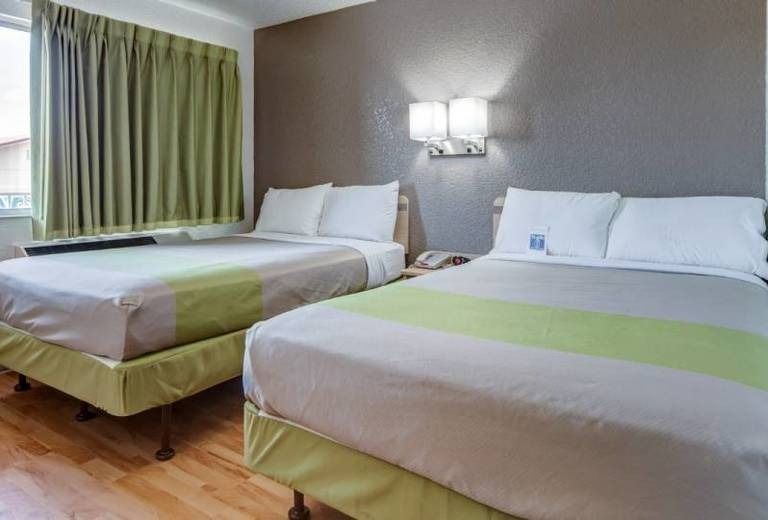 A hotel room with two beds and a window.