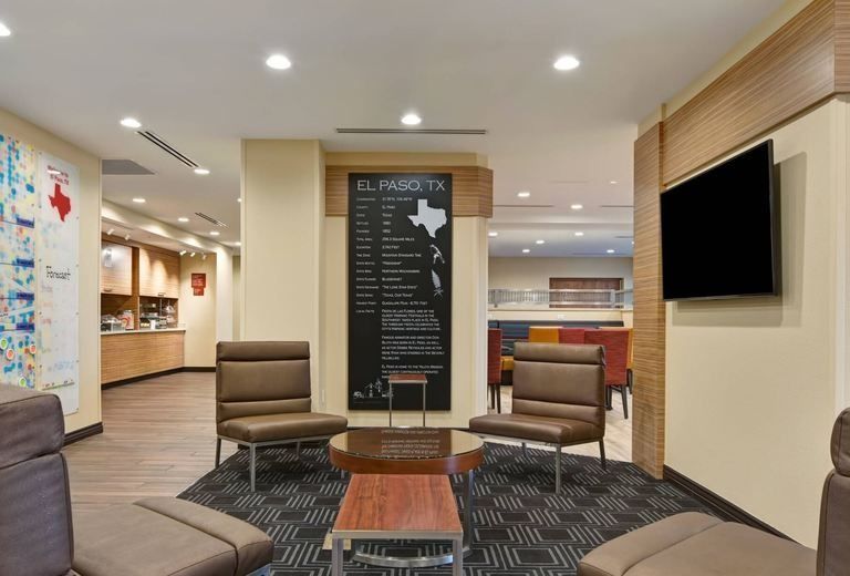 A living room with chairs , a table , and a flat screen tv.