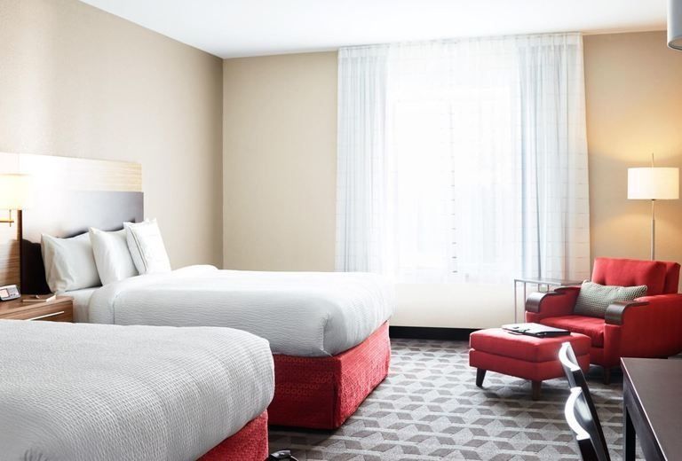 A hotel room with two beds and a red chair