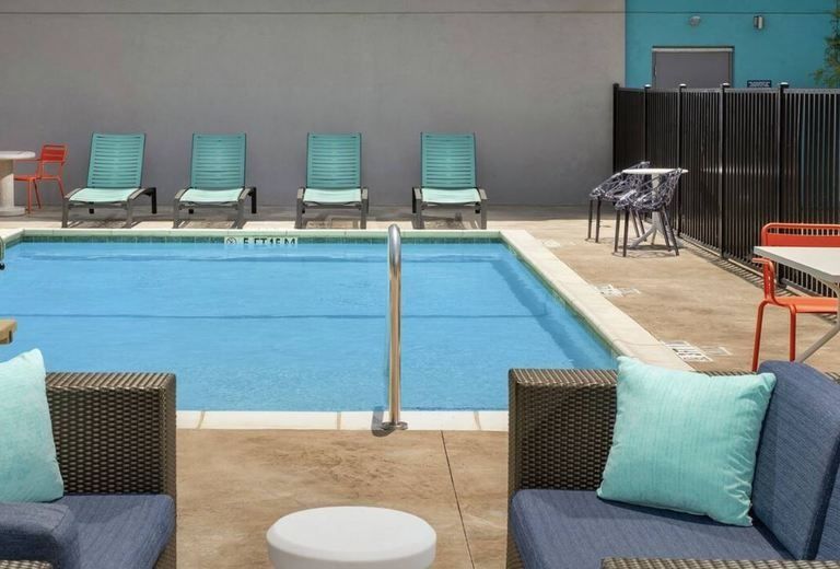 A swimming pool with chairs and a couch in front of it