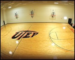 A uep logo is painted on the floor of a basketball court