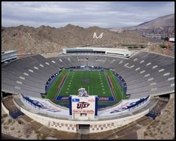 An aerial view of a football stadium with mountains in the background.