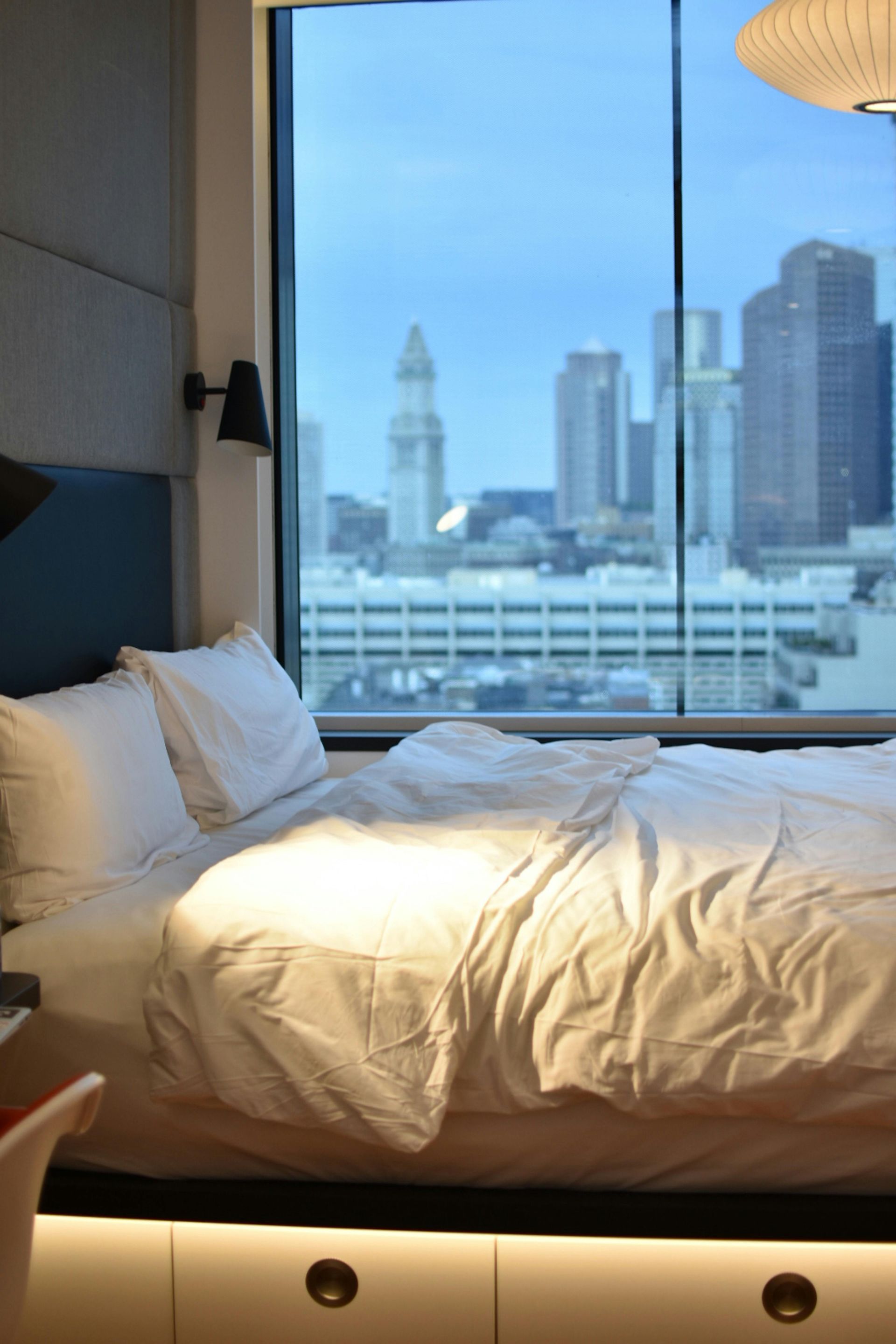 A hotel room with a bed and a view of the city