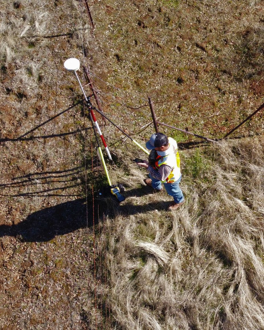 mapper working in the corner of a lot measuring elevation stats