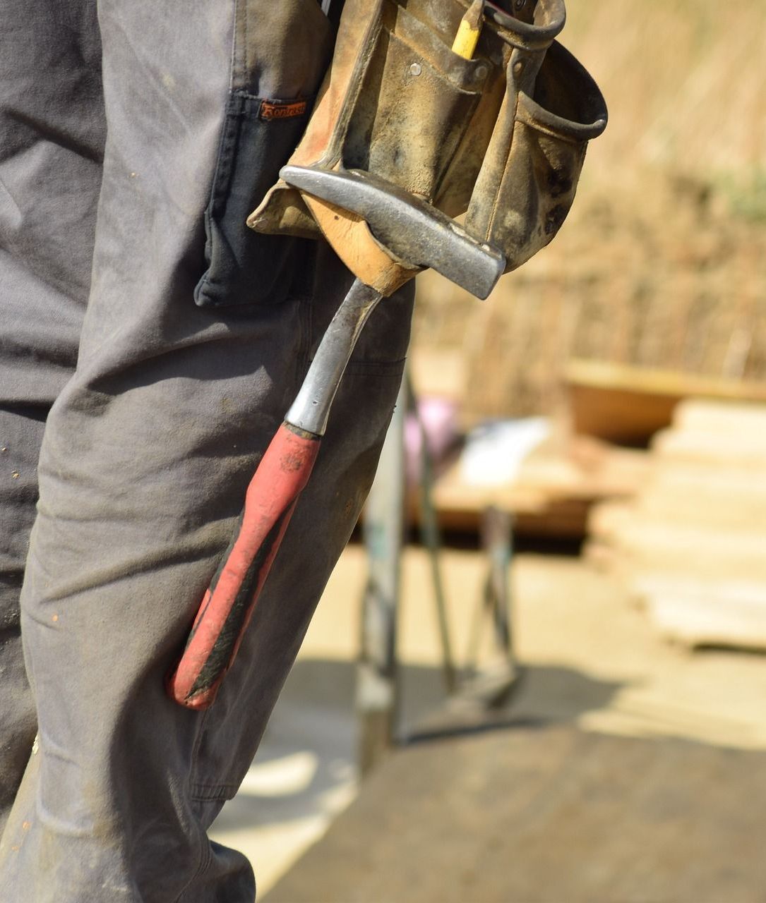 worker and hammer near stack of surveying stakes in the field