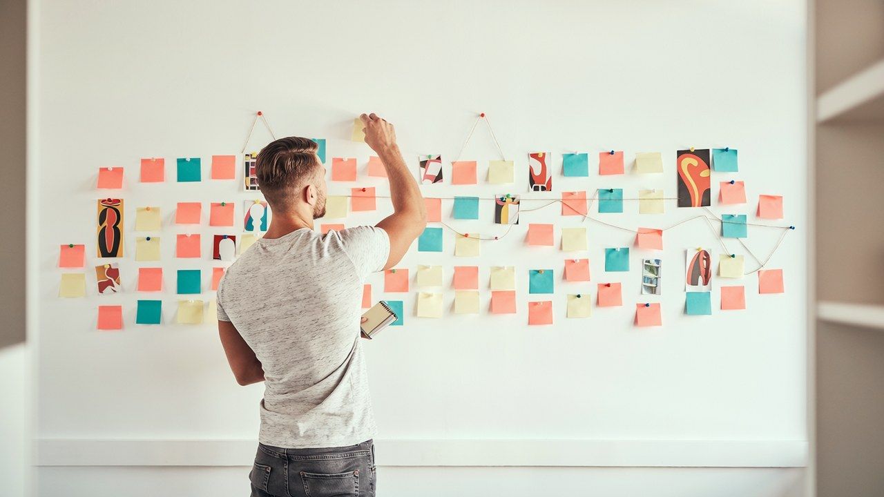 Creative team brainstorming wall of colorful notes and swatches, where fresh advertising ideas for a marketing strategy take shape