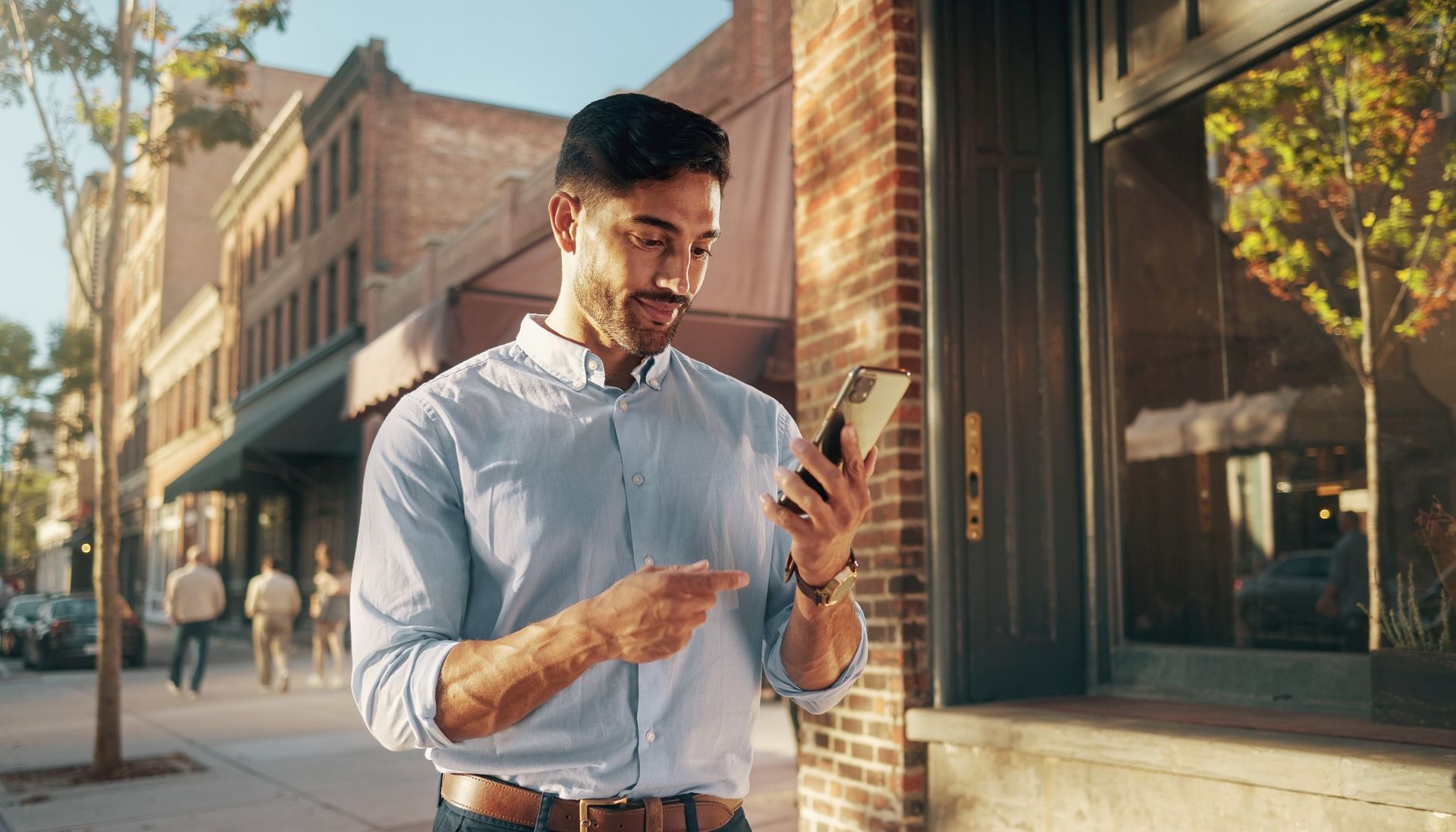 Reading, PA shop owner checking a business profile on a phone outside a brick downtown storefront, social media marketing for local buyers