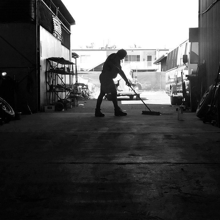 A Silhouette Of A Person Sweeping The Concrete Floor — Kings Brake Service Specialists in Tamworth, NSW