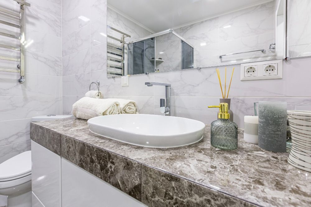 Small bathroom with white tub, sink, toilet, dark floor, and unfinished back wall.