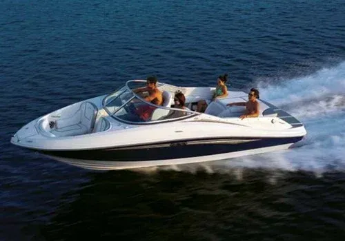 Speedboat cruising on open water with four passengers, leaving a white wake behind