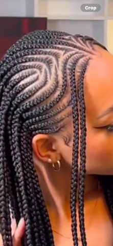 Close-up of cornrow braids on a person's head, featuring intricate patterned designs.