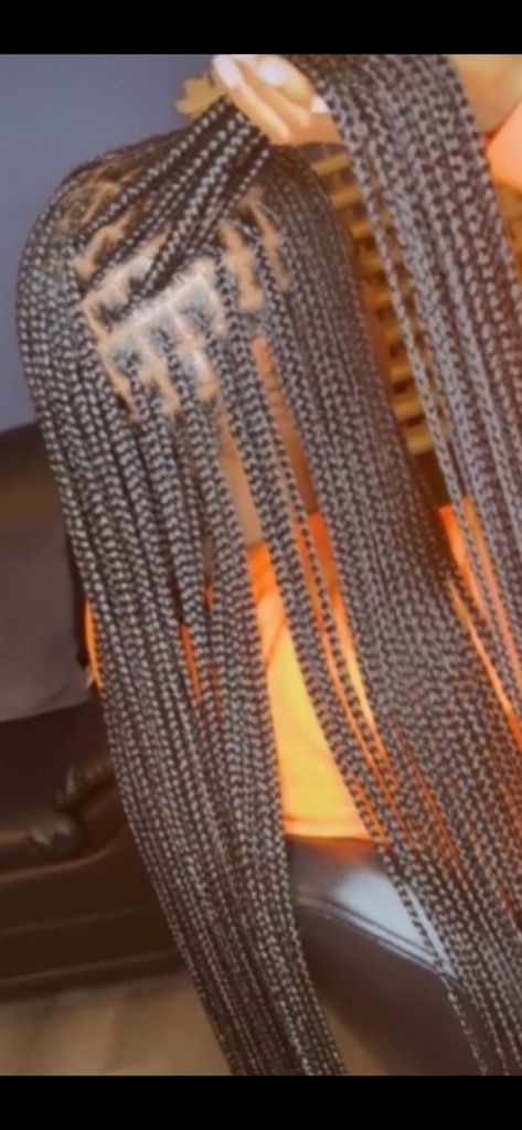 A close up of a person 's shoulder with braids.