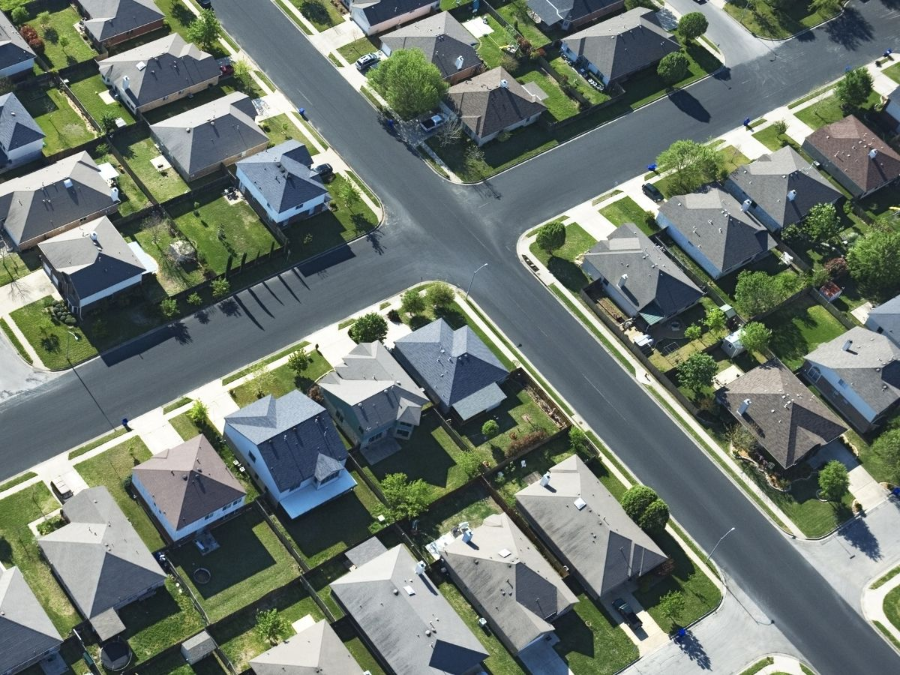 Aerial view of a suburban neighborhood with houses, streets, and intersecting roads.