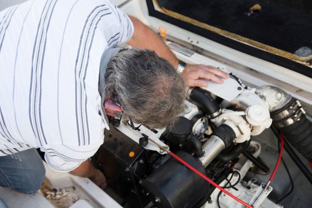 A Man is Working on the Engine of a Boat — Brittle's Family Auto Centre in Sunshine Coast, QLD