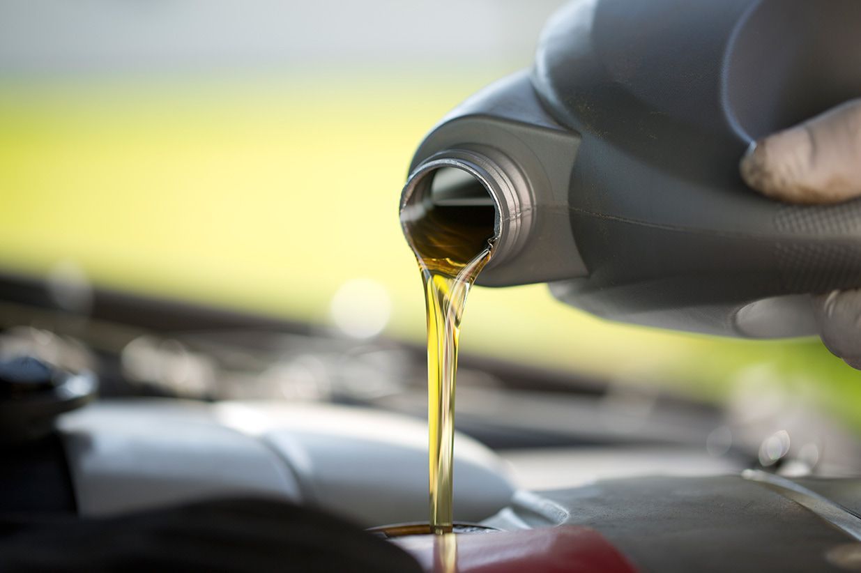 A Person is Pouring Oil Into a Car Engine — Brittle's Family Auto Centre in Sunshine Coast, QLD