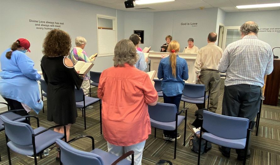 A group of people are standing in a circle in a room.