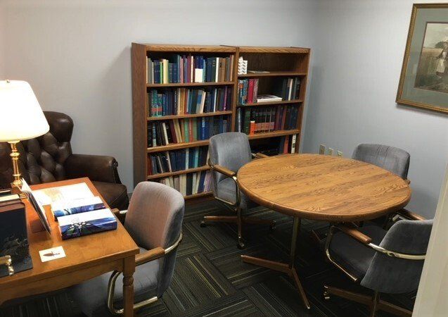 A room with a table and chairs and bookshelves