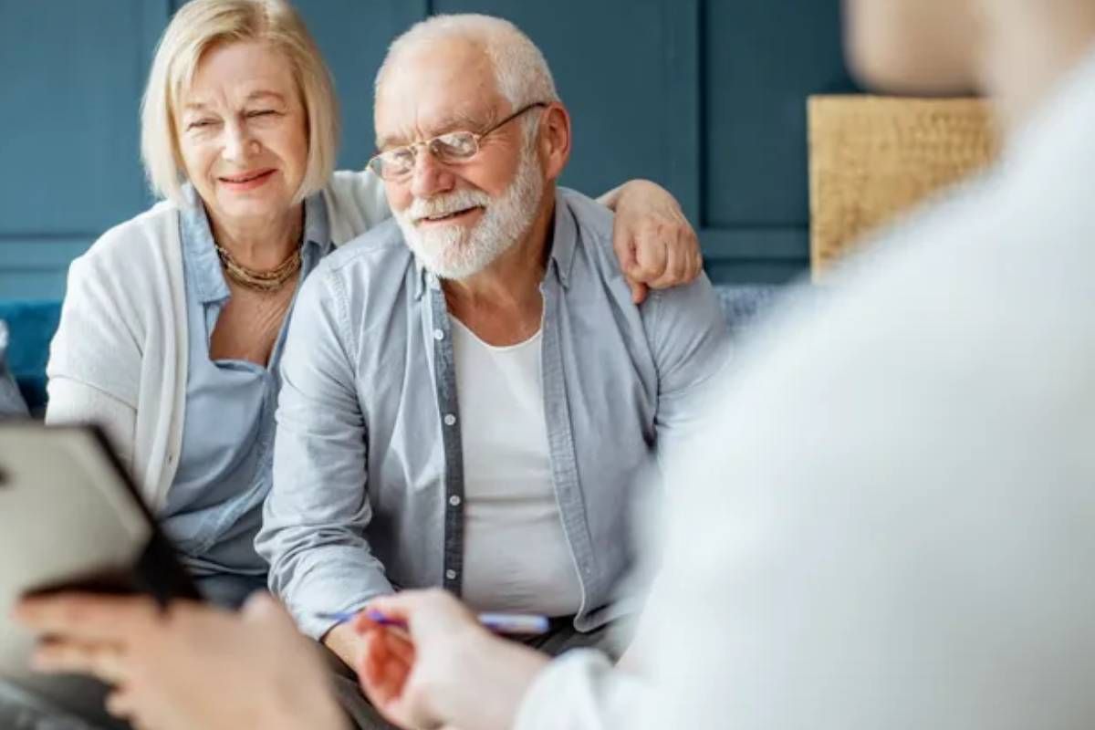 An older couple admiring a clipboard that someone is holding