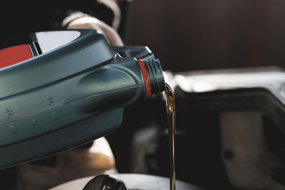 Fresh oil being poured during an oil change to a car — A Grade Oils & Batteries In Wodonga VIC