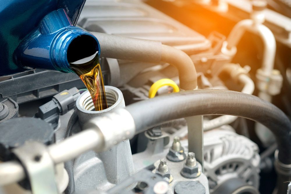 Mechanic replacing new oil — A Grade Oils & Batteries In Wodonga VIC