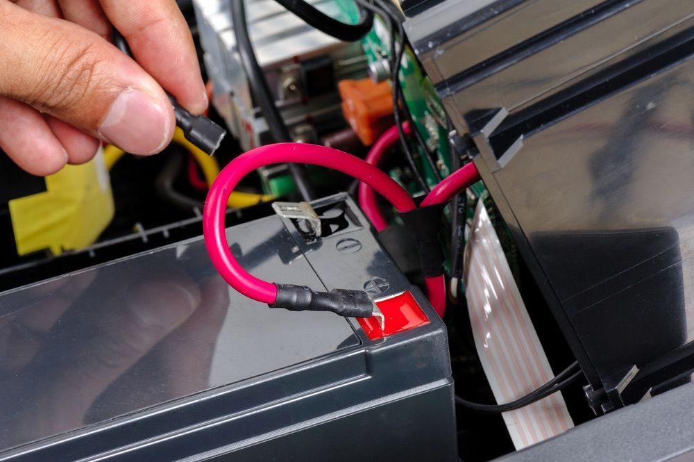 Technician replacing the battery — A Grade Oils & Batteries In Wodonga VIC