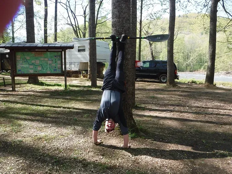 A man is doing a handstand in the woods