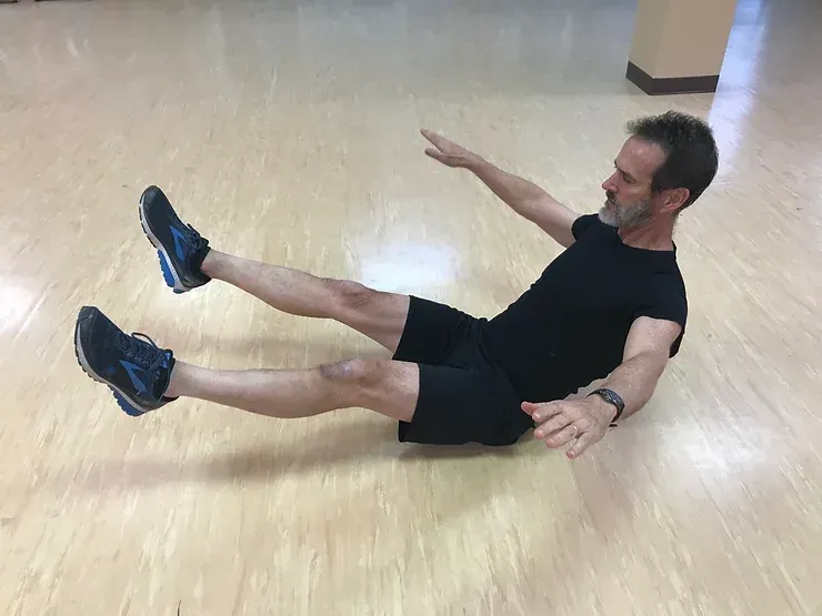 A man is laying on the floor with his legs crossed.