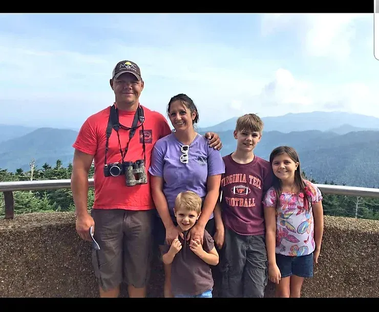 A family posing for a picture with mountains in the background