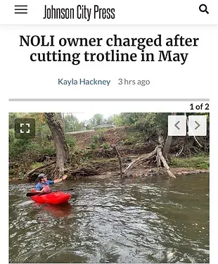 A person in a red kayak is floating down a river.