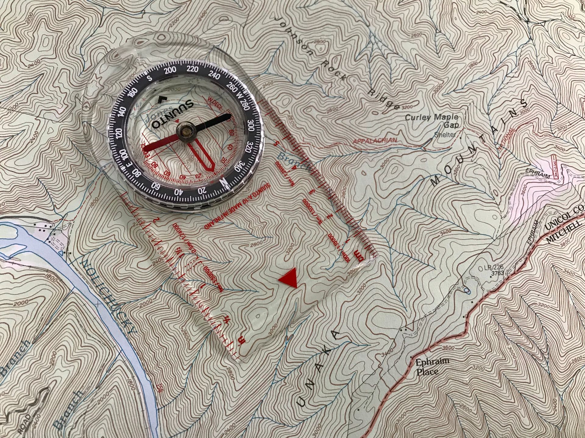 A compass is sitting on top of a map.
