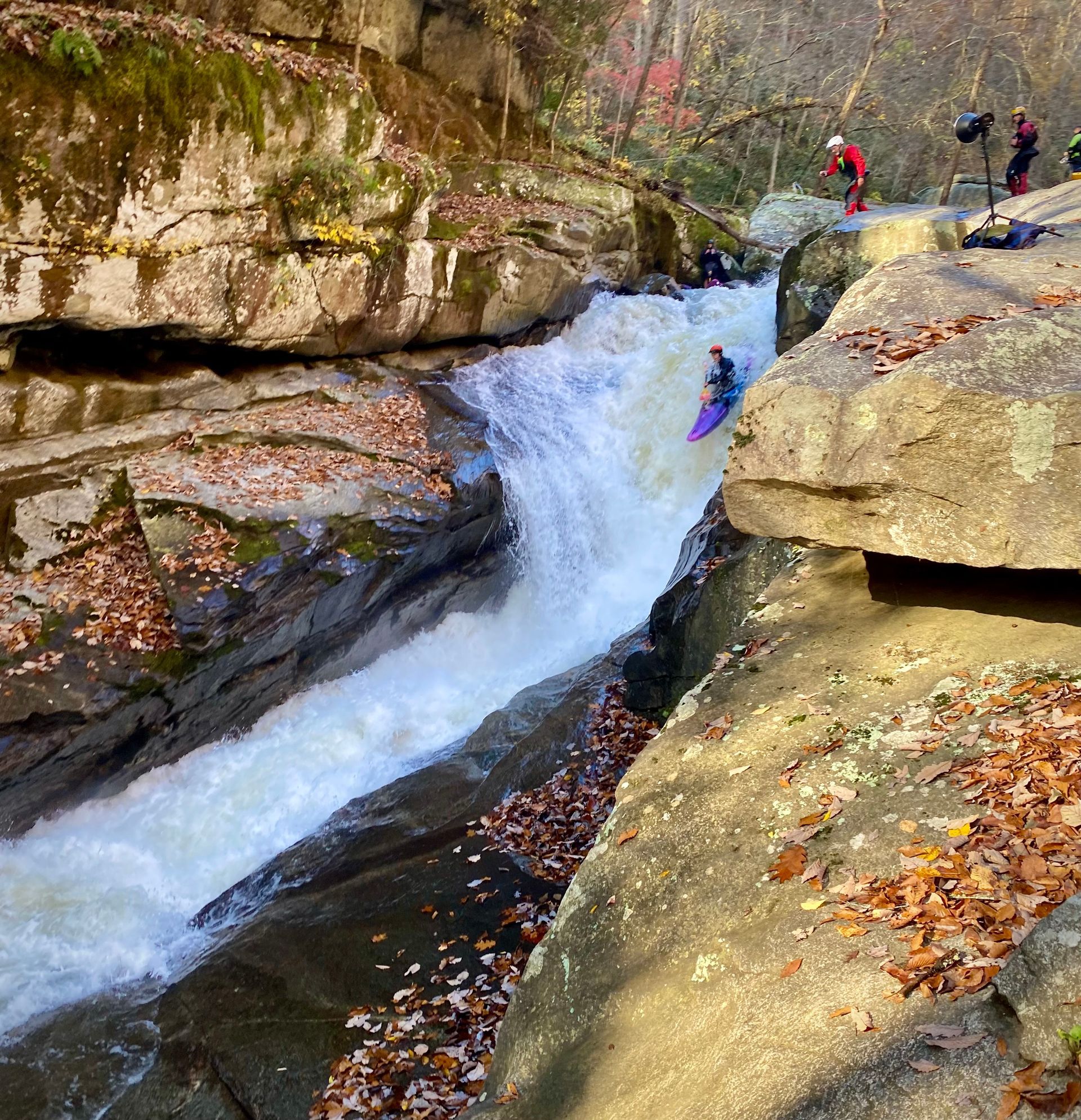 A person in a kayak is going down a waterfall.