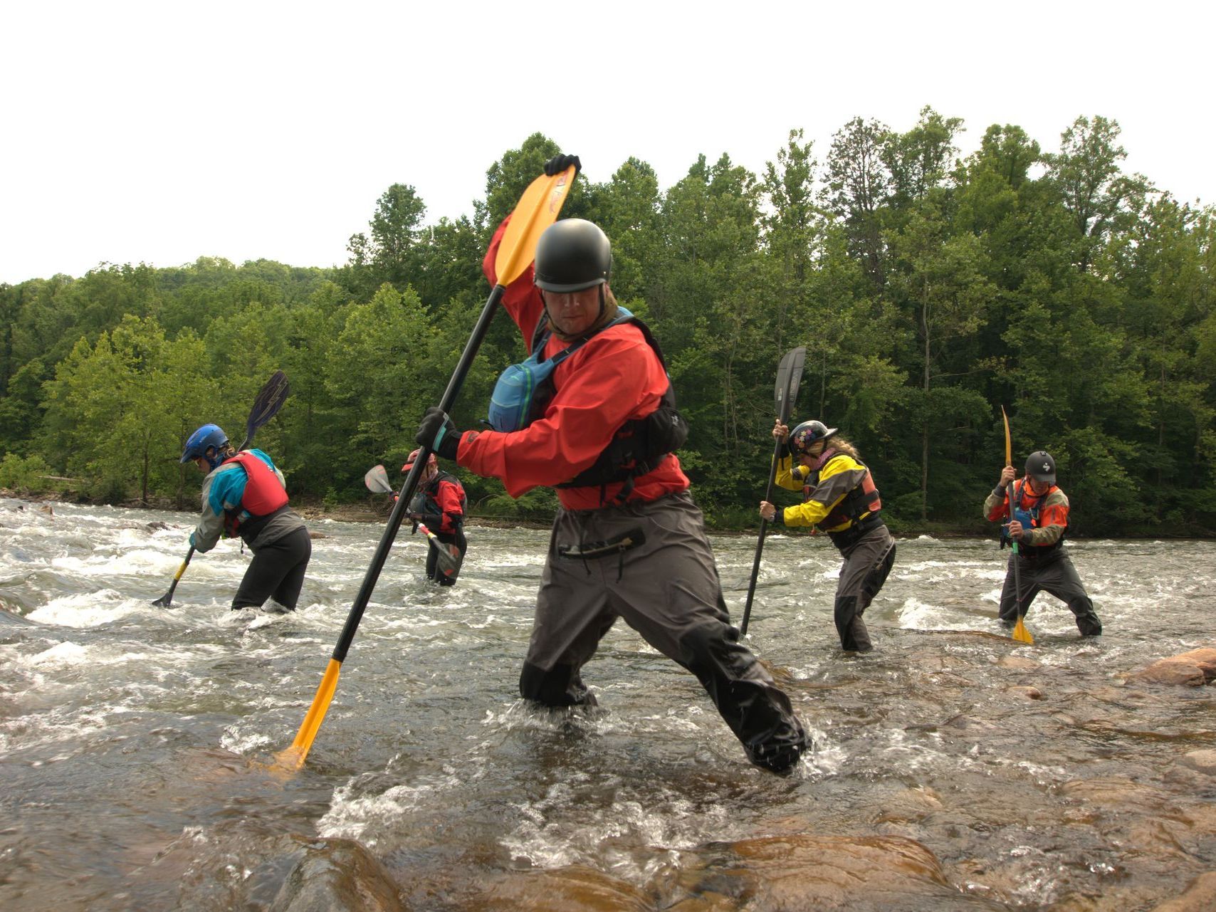 A group of people are paddling down a river.