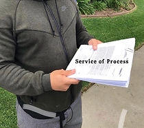 Person holding a stack of legal papers labeled “Service of Process” outdoors