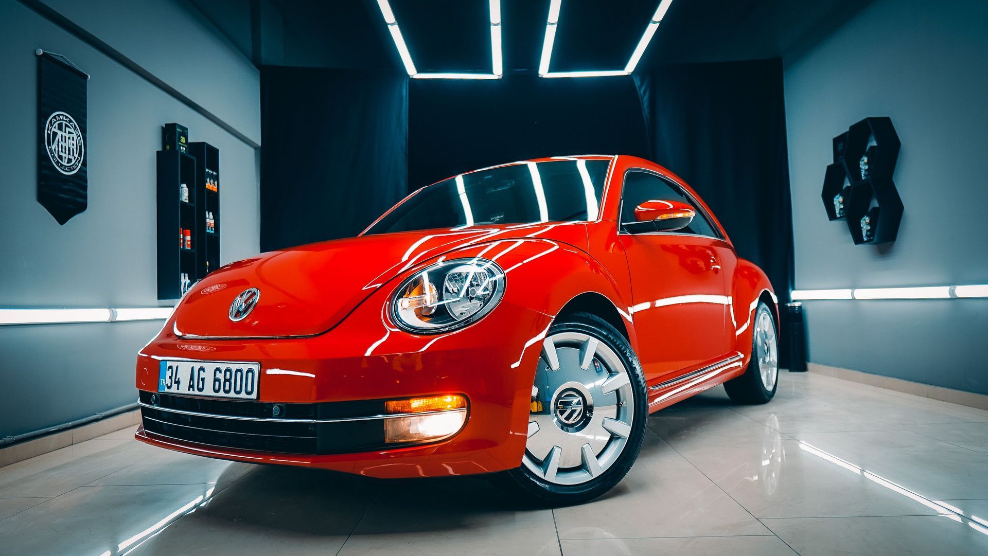 Red Volkswagen Beetle in a modern showroom with blue neon ceiling lights