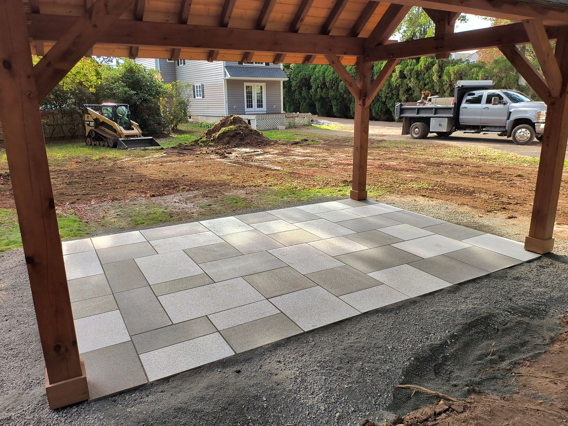 Stone retaining wall with built-in lights in front of a house with a deck and stairs.