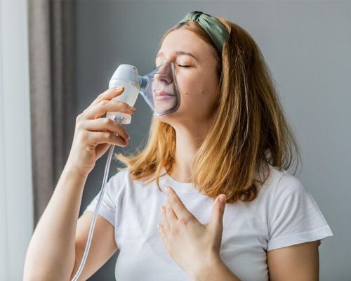 A woman is wearing an oxygen mask on her face.